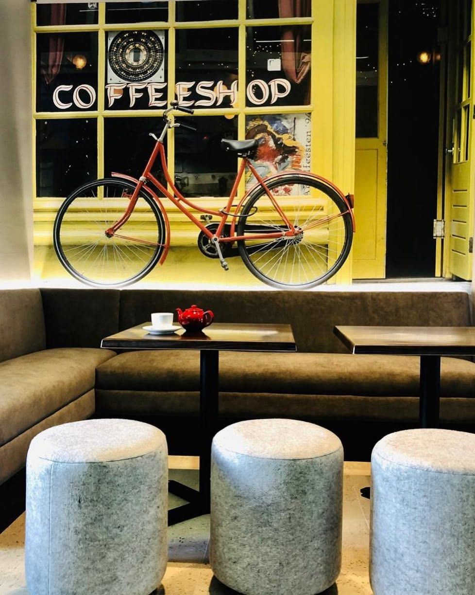 Amsterdam street scene wallpaper in a coffee shop with a bicycle and booth seating