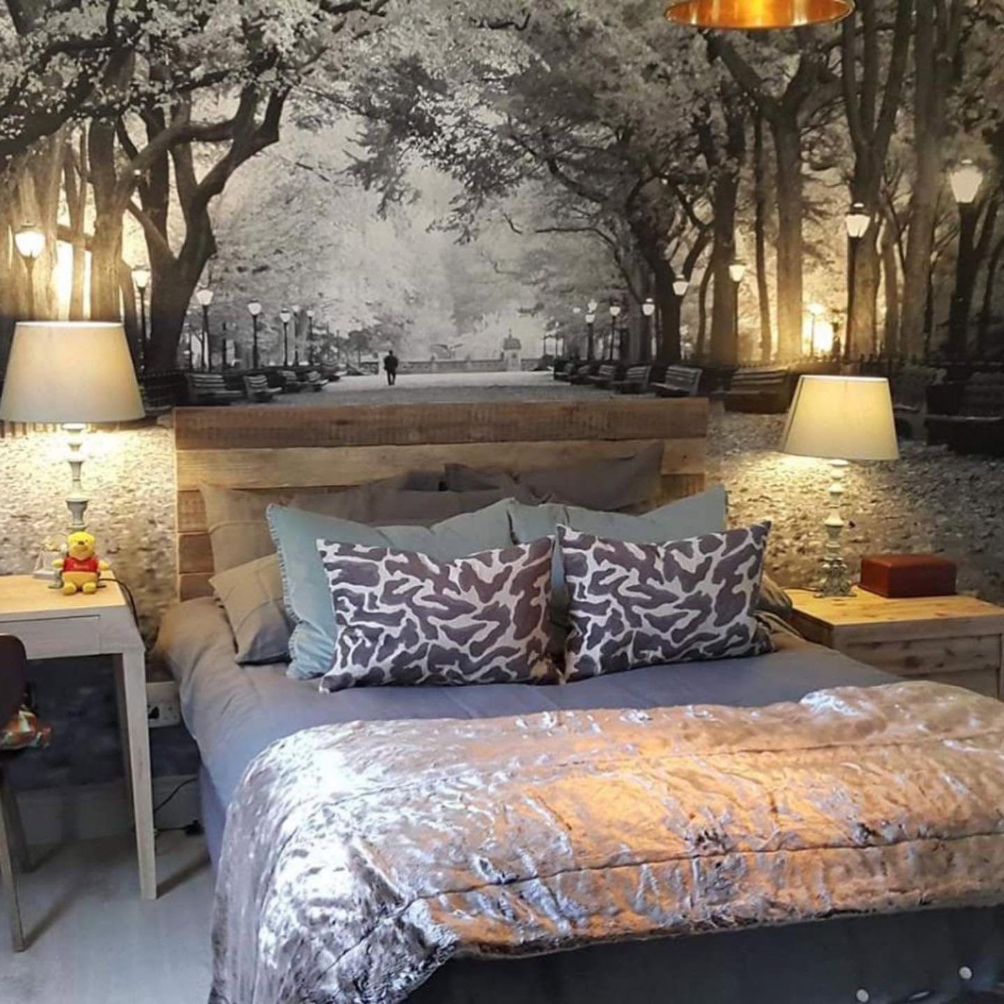 Monochrome tree-lined avenue mural behind a bed