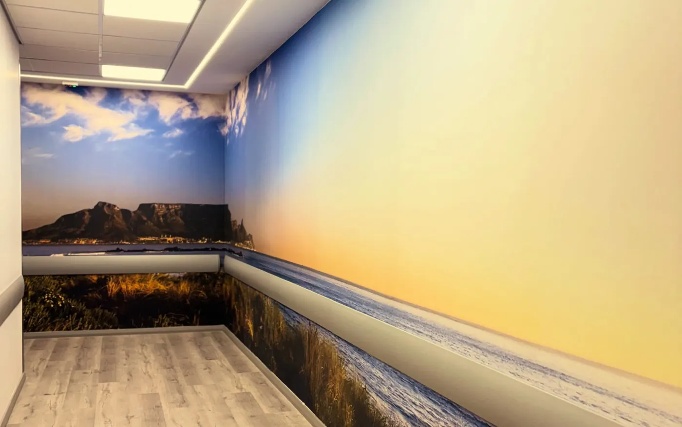 Corridor wrapped in a beach and sunset mural with Table Mountain at the far end