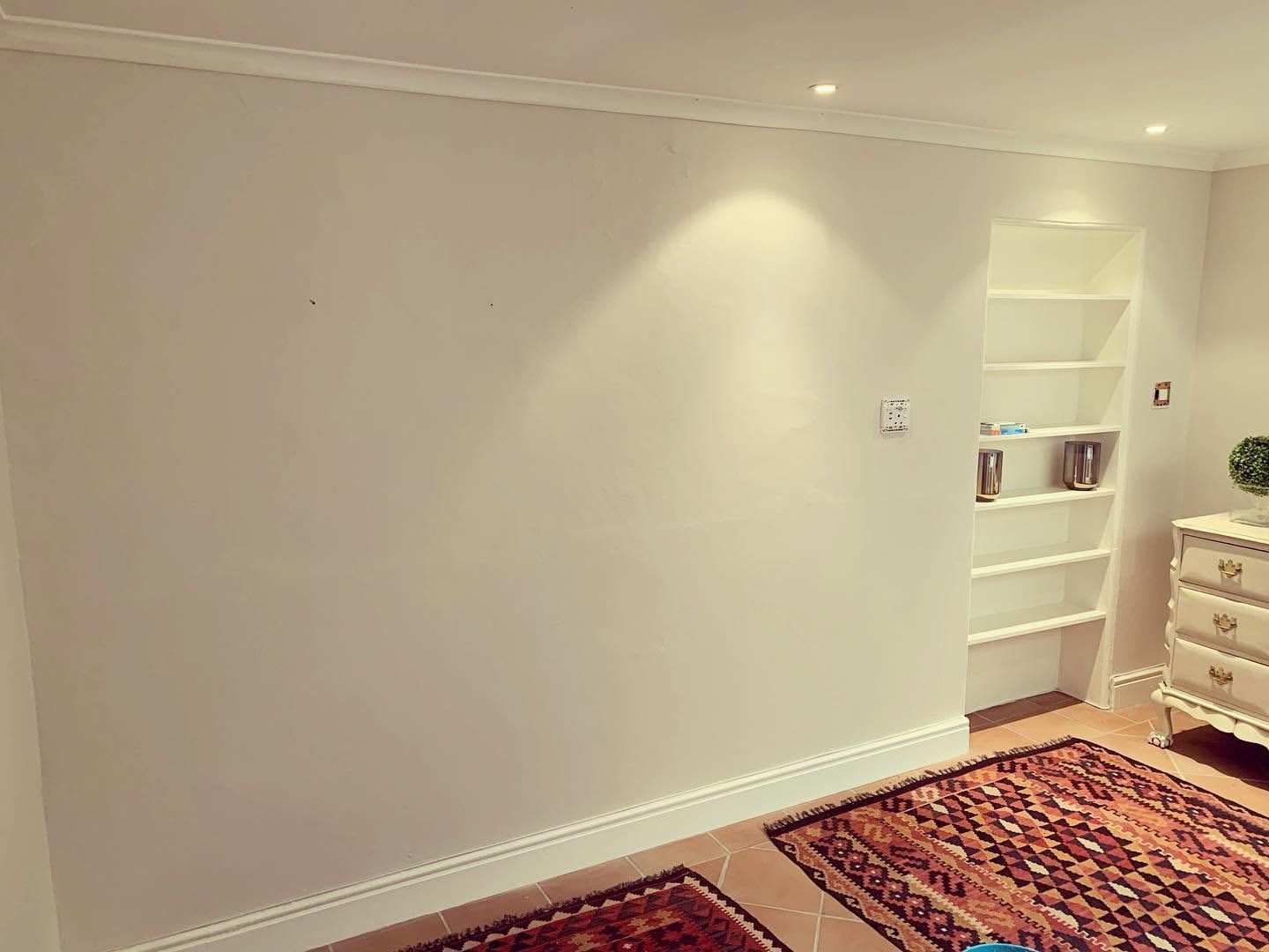 Bare white bedroom wall before wallpapering