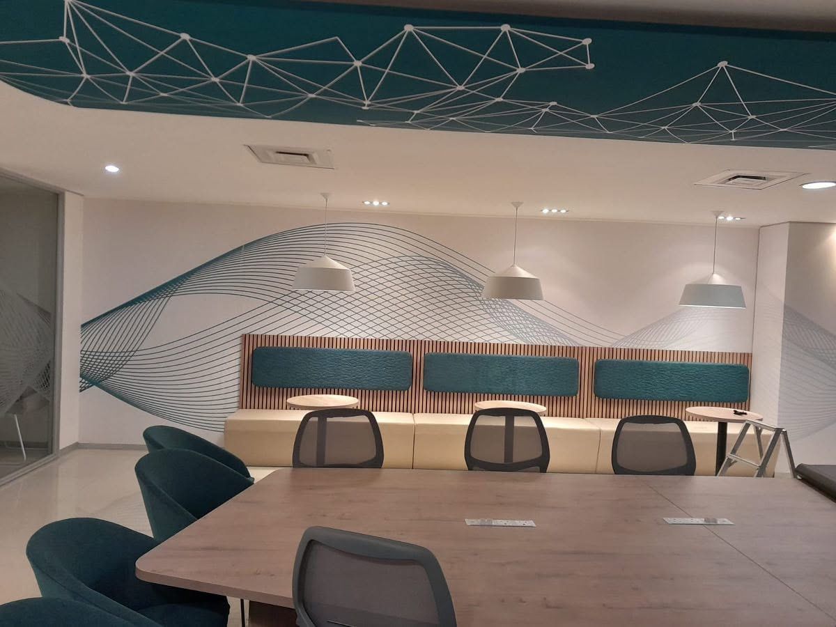 Office with a geometric printed ceiling panel and a flowing line graphic along the wall