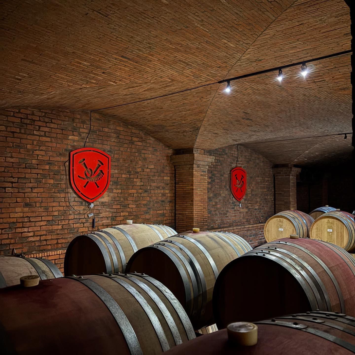 Two red crests on the brick walls of La Motte's barrel cellar