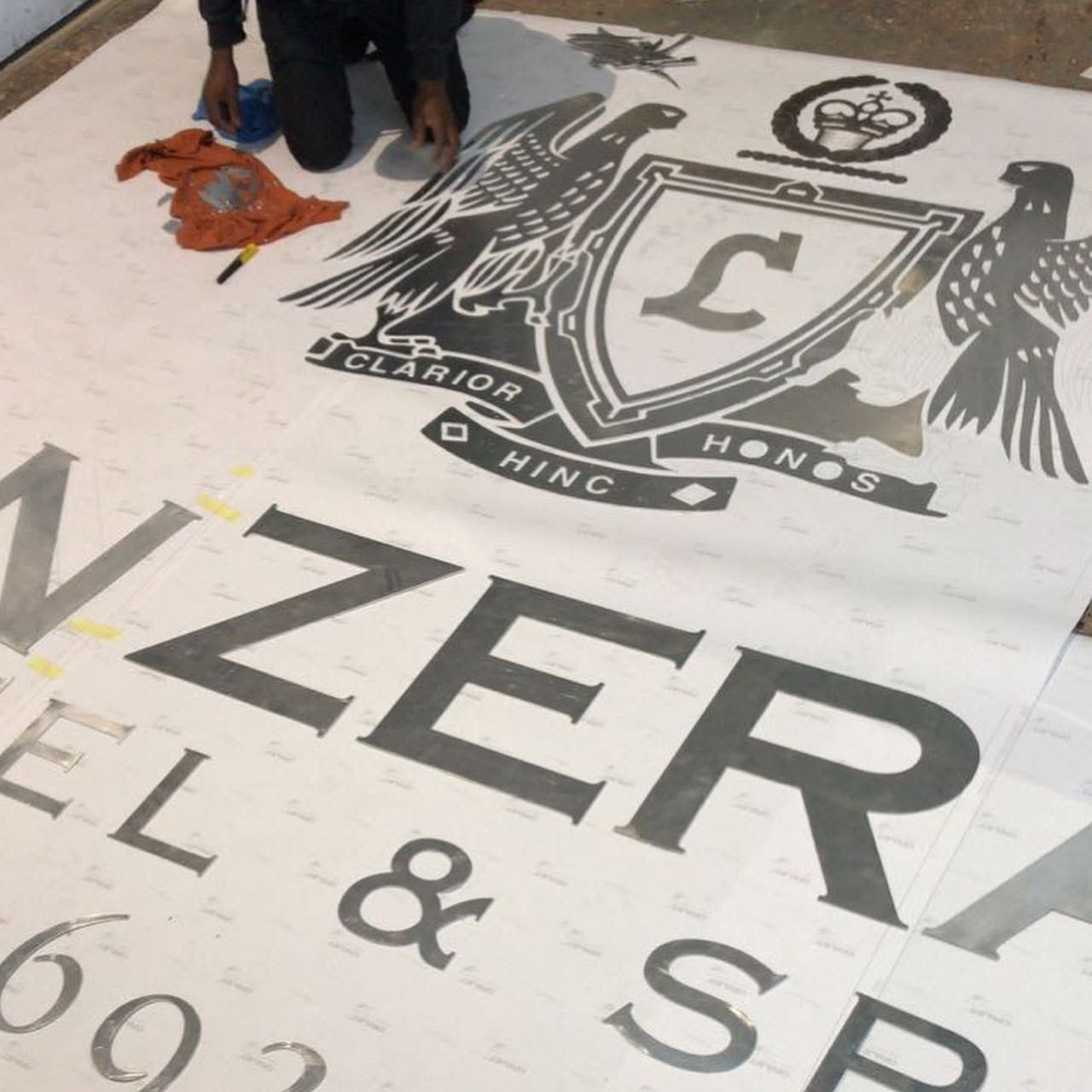 Full-size Lanzerac crest artwork laid out on the floor during production