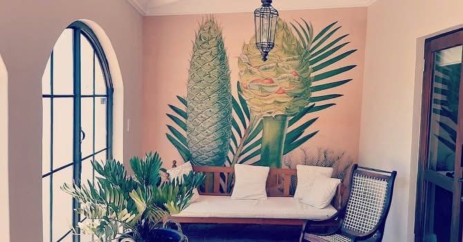 Botanical cycad mural in a room with arched windows