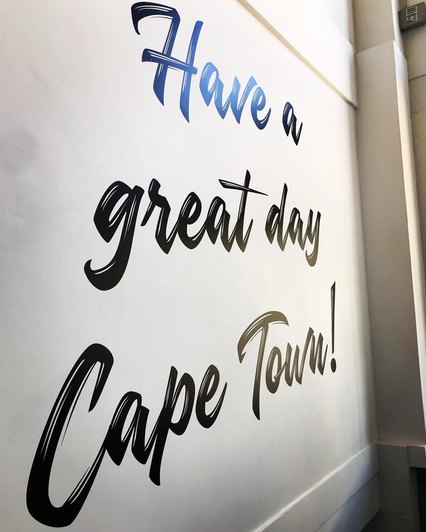 Cut vinyl lettering reading Have a great day Cape Town on a white wall