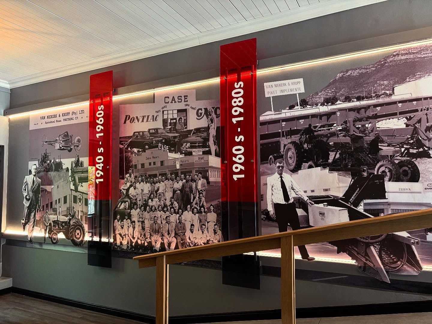Heritage timeline wall with black and white photographs from the 1940s to the 1980s
