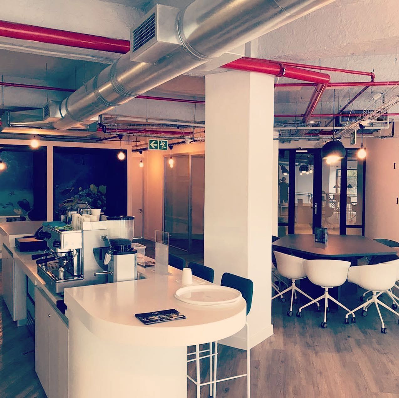 Open-plan office with branded wall graphics and exposed ceilings