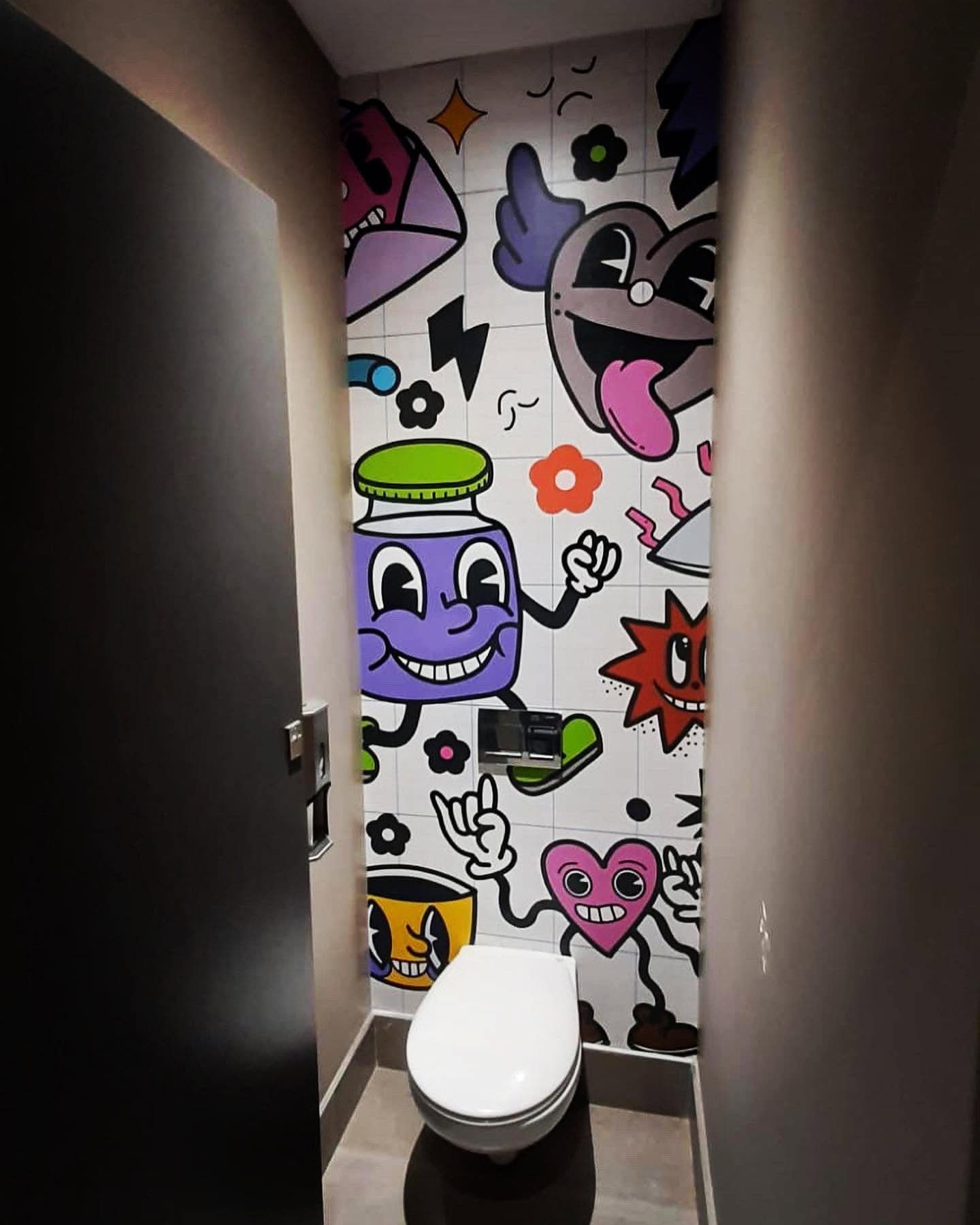 Washroom wall covered in a cartoon pop art mural