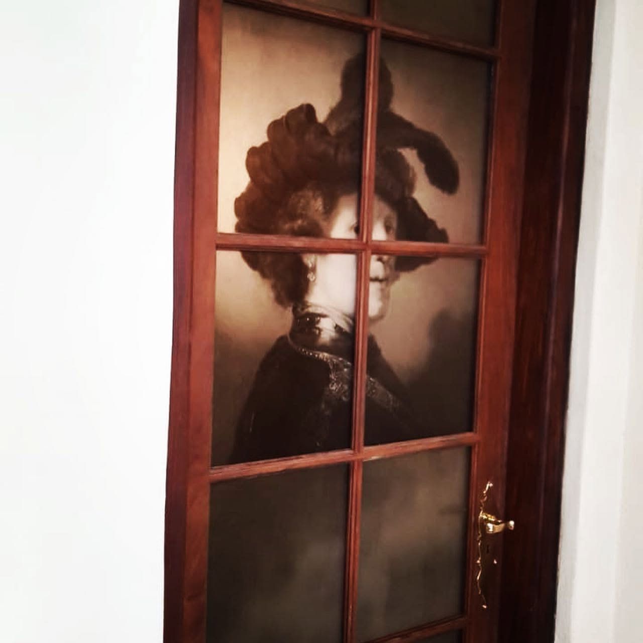Rembrandt portrait printed across the panes of a wooden glass door