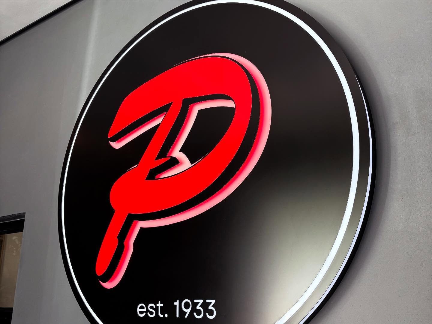 Round black Piket logo sign with a raised red P and est. 1933