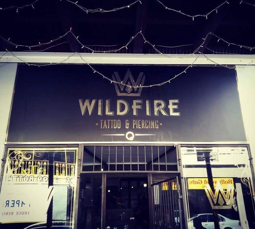Wildfire Tattoo and Piercing shopfront sign in gold on black