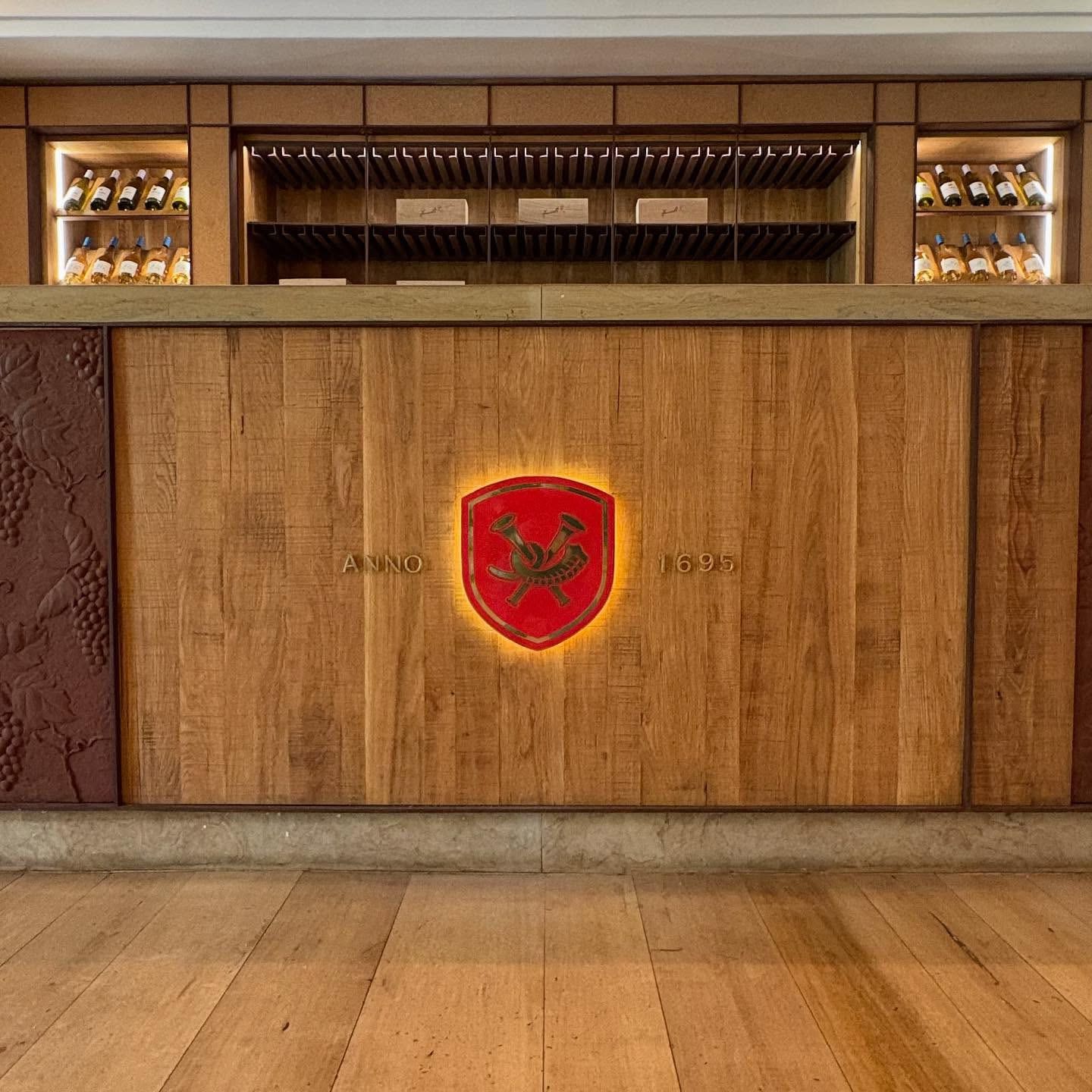 La Motte crest glowing on the front of an oak tasting counter
