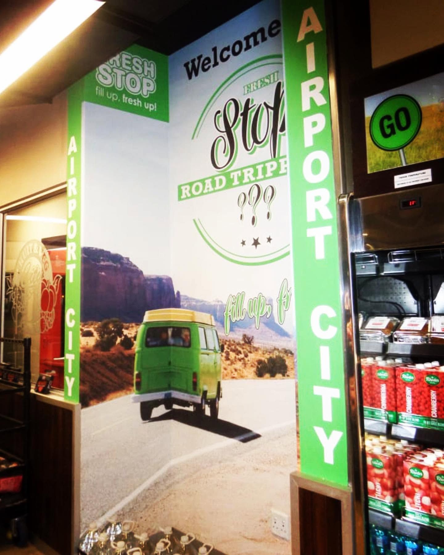 Road-trip wall graphic inside a Fresh Stop convenience store